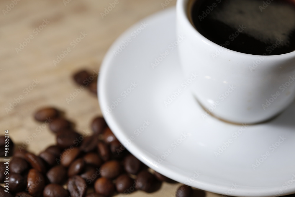 Coffee beans and white cup close up Coffee beans and white cup close up