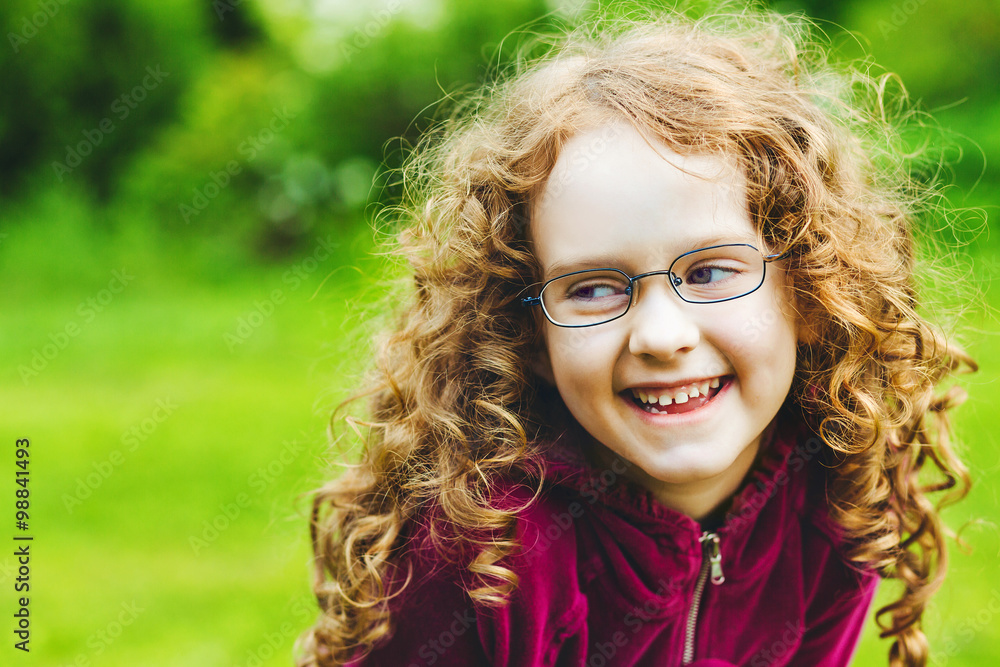 Laughing little girl in eyeglasses in spring park. Laughing little girl in eyeglasses in spring park.