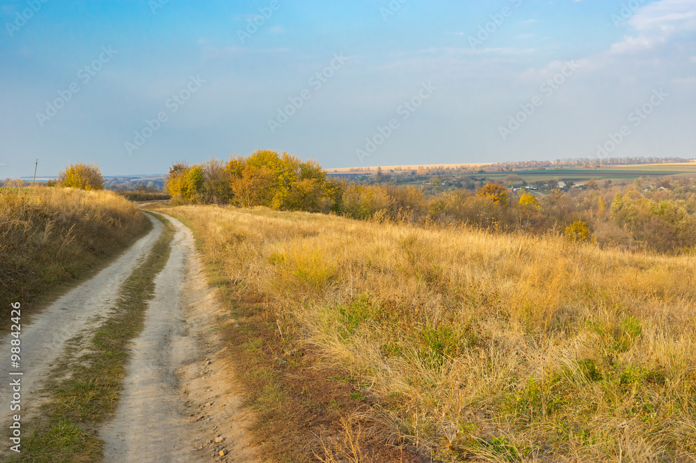 Pastel landscape with earth road leading to remote village Grusheve in Sumskaya oblast, Ukraine