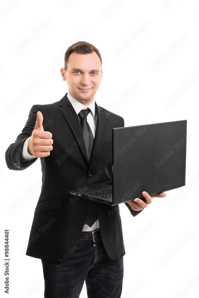 Young businessman holding a laptop giving a thumbs up Young businessman holding a laptop giving a thumbs up