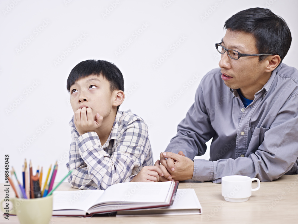 asian father and son having a serious conversation asian father and son having a serious conversation
