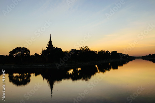 Silhouette scene of moat and Fort of Mandalay palace at sunset