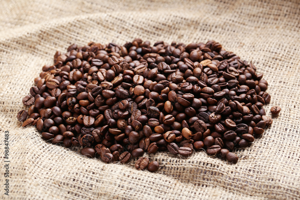 Roasted coffee beans on a sack, close up Roasted coffee beans on a sack, close up