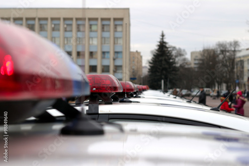 Row of police cars, with blue and red flashing sirens, Ukraine, selective focus