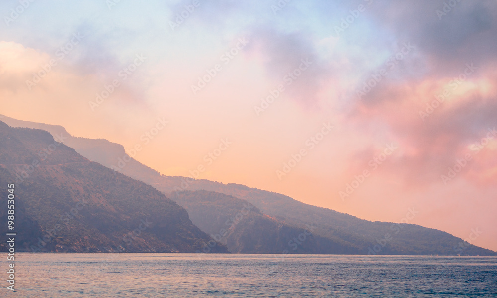 Mountains landscape on the coast at sunrise - serenity and rose quartz colors.