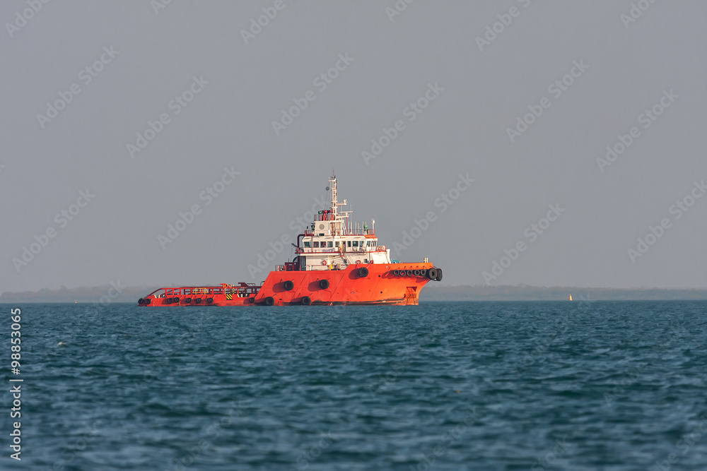 Orange rescue ship sails across the bay at sunset. Orange rescue ship sails across the bay at sunset.