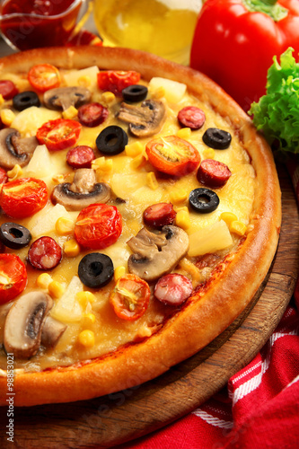 Delicious pizza with vegetables, meat on red napkin, close-up