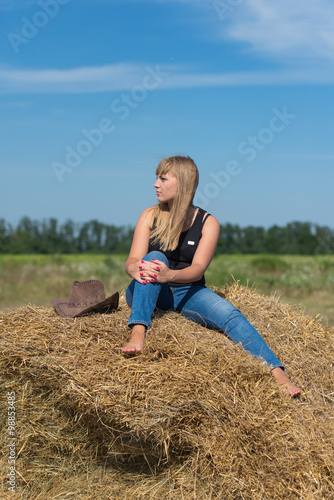 Canvas Print Pretty young girl on a haystack