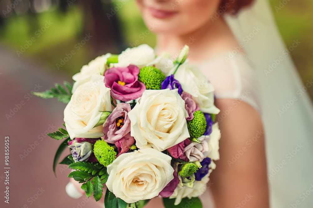 bride holding colour wedding bouquet of flowers