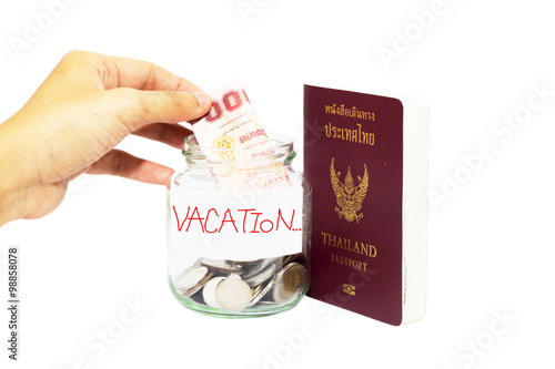 фотографія Hand puts money ,  vacation money savings in a glass jar