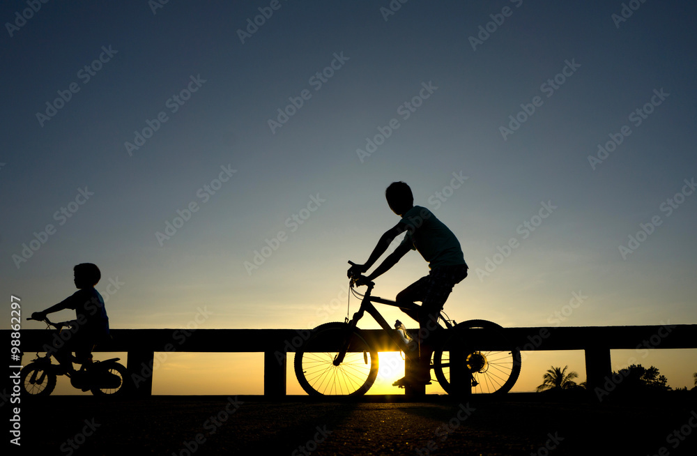 Obraz premium Silhouette motion cyclist bicycles against sunset