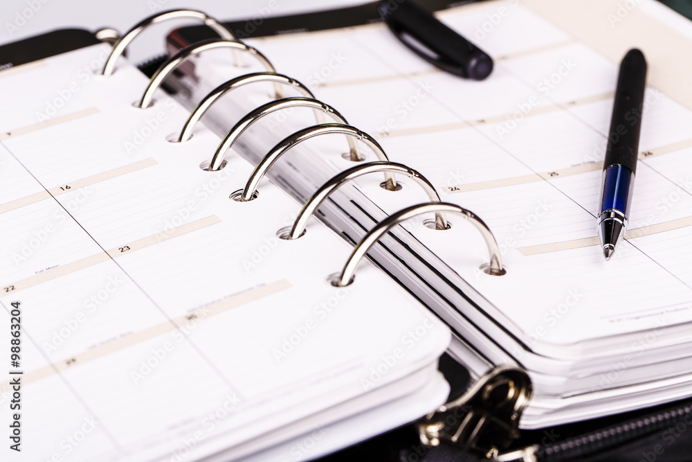 Personal organizer or planner with pen on white background Personal organizer or planner with pen on white background