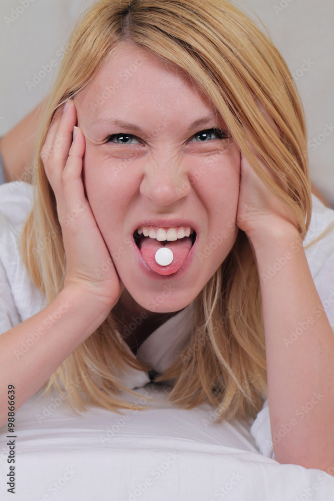 Don't like taking medicine : woman holding pill on her tongue with disgusted face emoticon