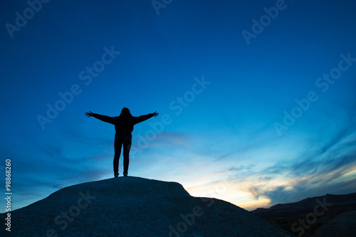 woman jumping against sunset with blue sky