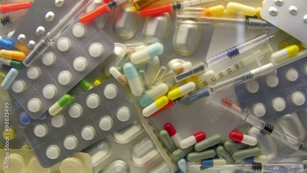 Tablets capsules and syringes on a glass cabinet. They are medicines used by sick people and are prescribed by the doctors Tablets capsules and syringes on a glass cabinet. They are medicines used by sick people and are prescribed by the doctors