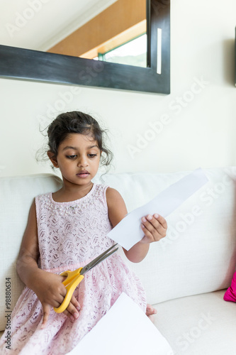 Little girl use the scissor for cutting paper