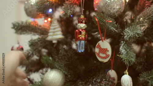 Man's hand shakes Christmas toys on the Christmas tree. photo