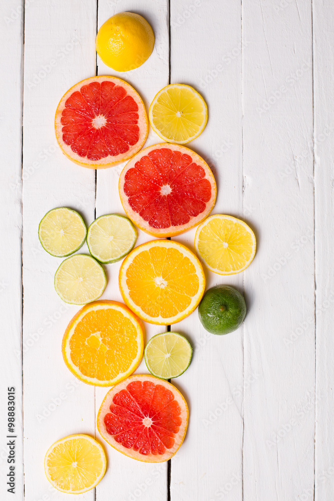 Lemon, tangerine, orange and pink grapefruit on white wood Lemon, tangerine, orange and pink grapefruit on white wood