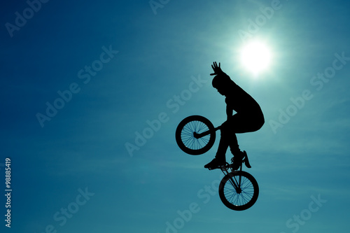 Extreme Silhouette man doing jump with a bmx bike.