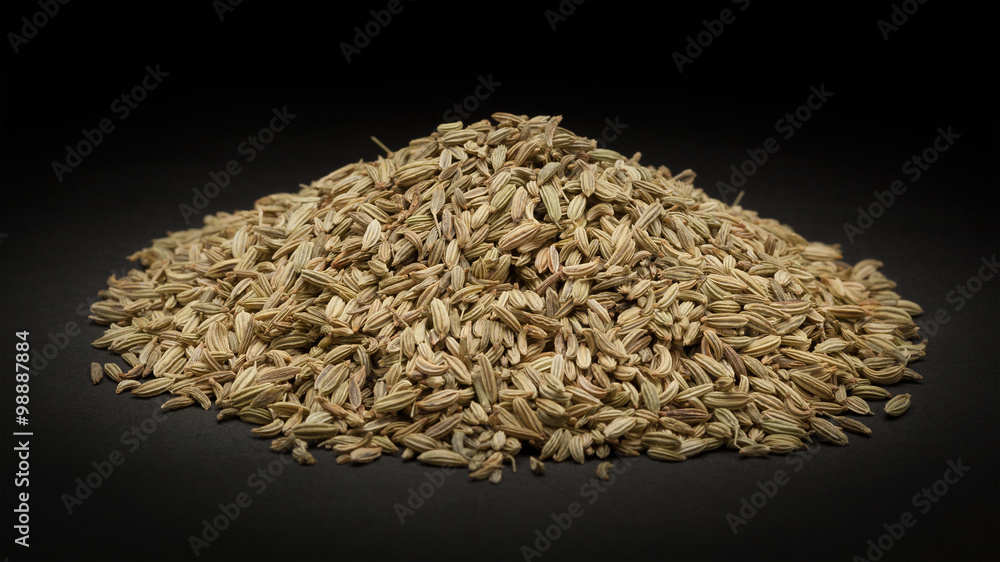 Pile of Organic Fennel seed (Foeniculum Vulgare) on dark background.