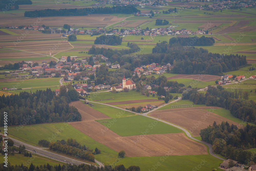 Aerial view of a traditional Slovenian village with a church.