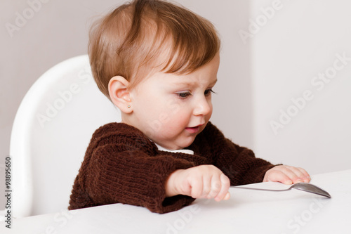 one year old baby sitting in baby chair photo