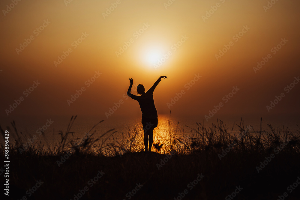 silhouette of girl at sunset on the ocean
