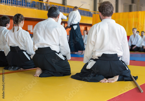 People in kimono and hakama sitting on tatami on martial arts training