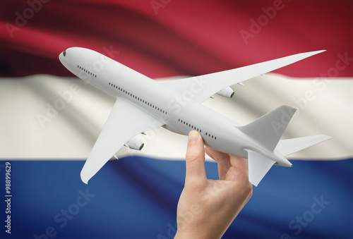 Airplane in hand with flag on background - Netherlands photo