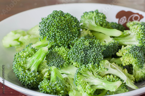Fresh green broccoli on white dish.