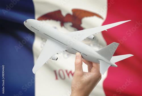 Airplane in hand with US state flag on background - Iowa photo