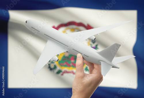 Airplane in hand with US state flag on background - West Virginia
