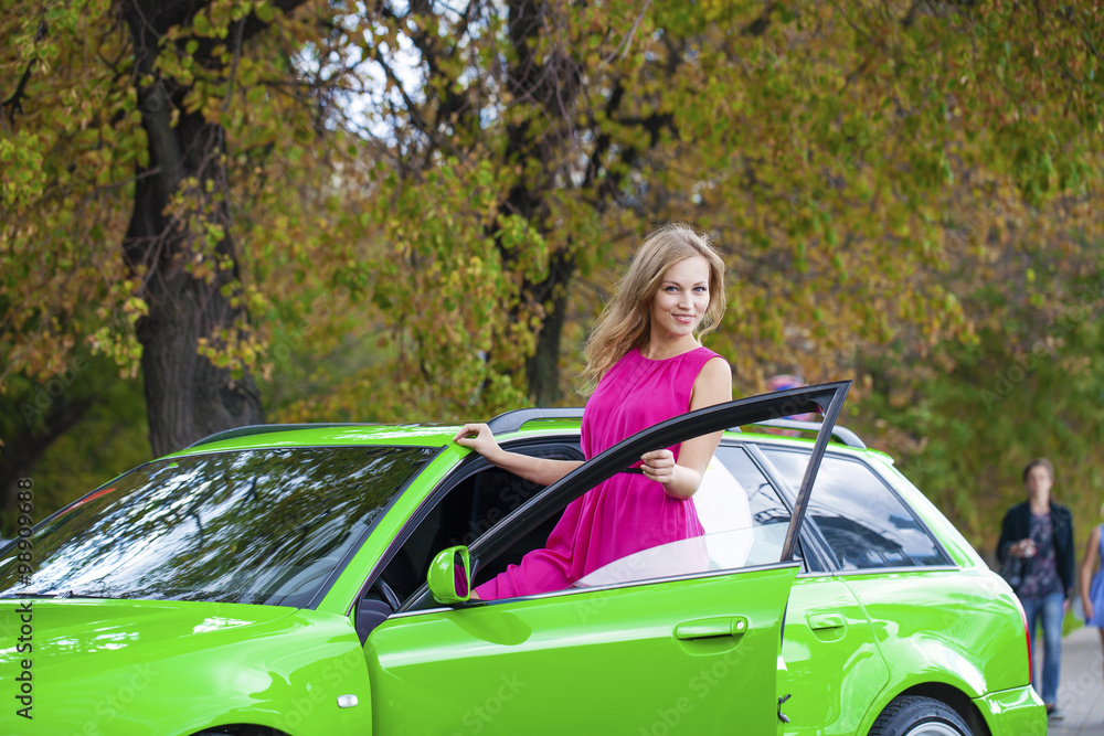 Portrait of a beautiful blonde woman and green sports car Portrait of a beautiful blonde woman and green sports car