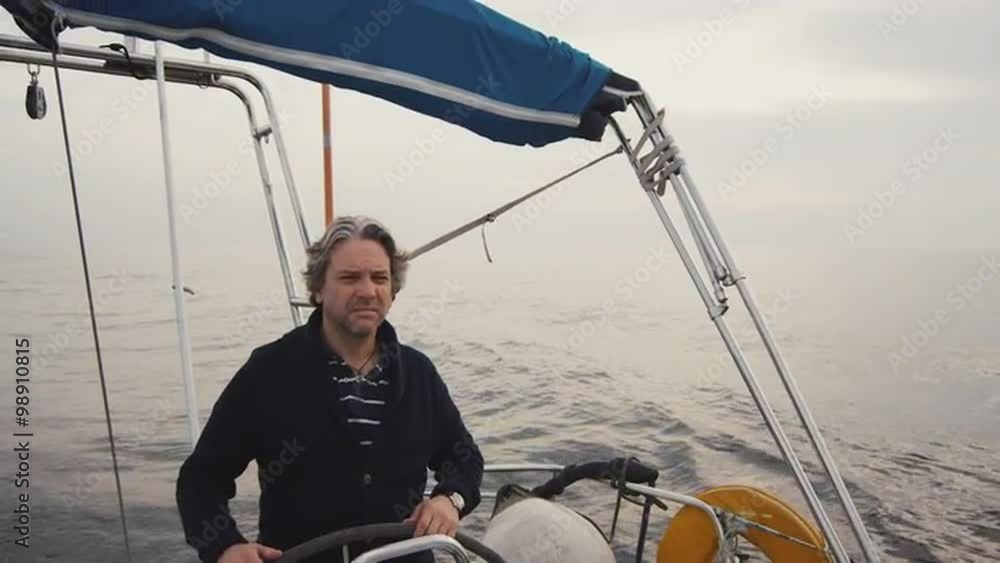 Senior man is driving a sailing boat in the sea. Shot on RED Cinema Camera. Senior man is driving a sailing boat in the sea. Shot on RED Cinema Camera.