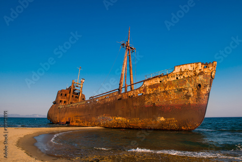 Old Ship. Ancient shipwrecks in the sea with sunset background. Dimitrios shipwreck at Selinitsa beach near Gytheio, Greece
