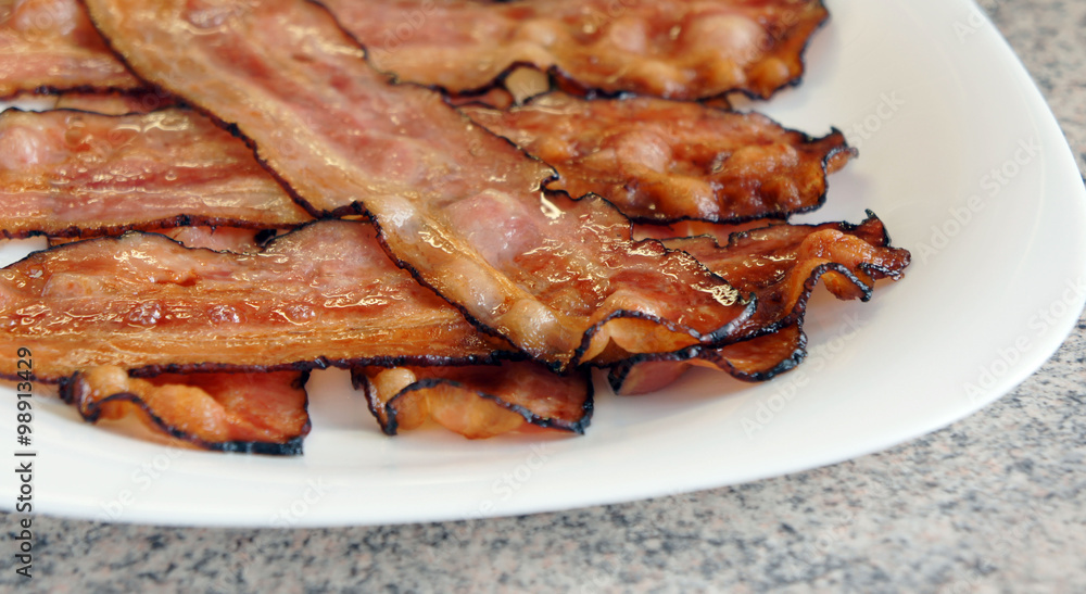 Fried bacon - delicious plate of sliced bacon Fried bacon - delicious plate of sliced bacon