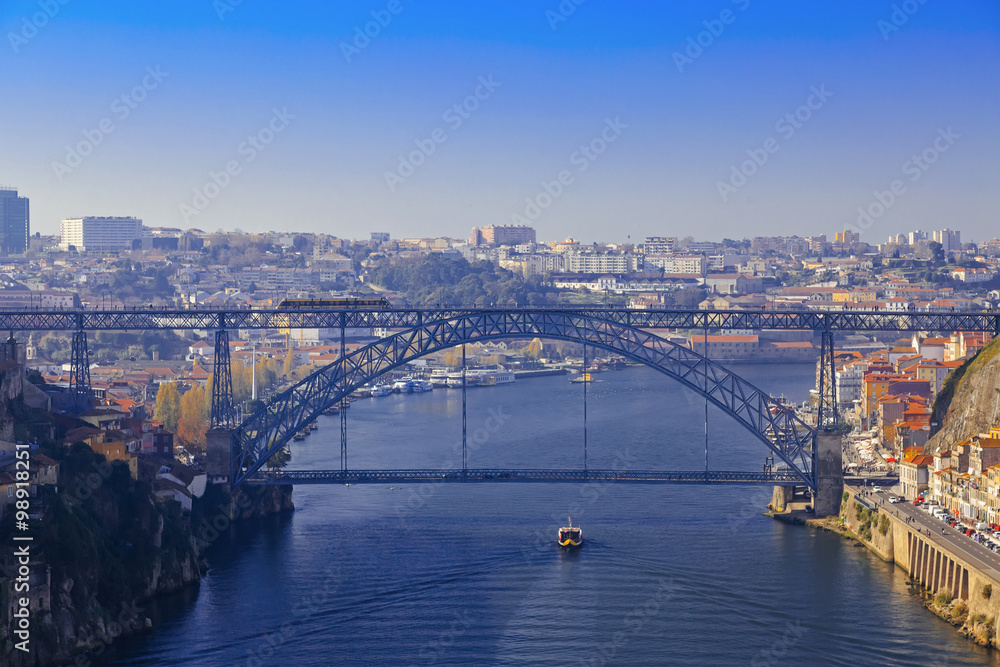 Luis I bridge and small ship sailing the river in Porto