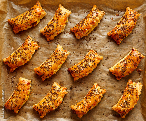 Pasties with puff pastry stuffed with cabbage and mushrooms sprinkled with caraway seeds photo