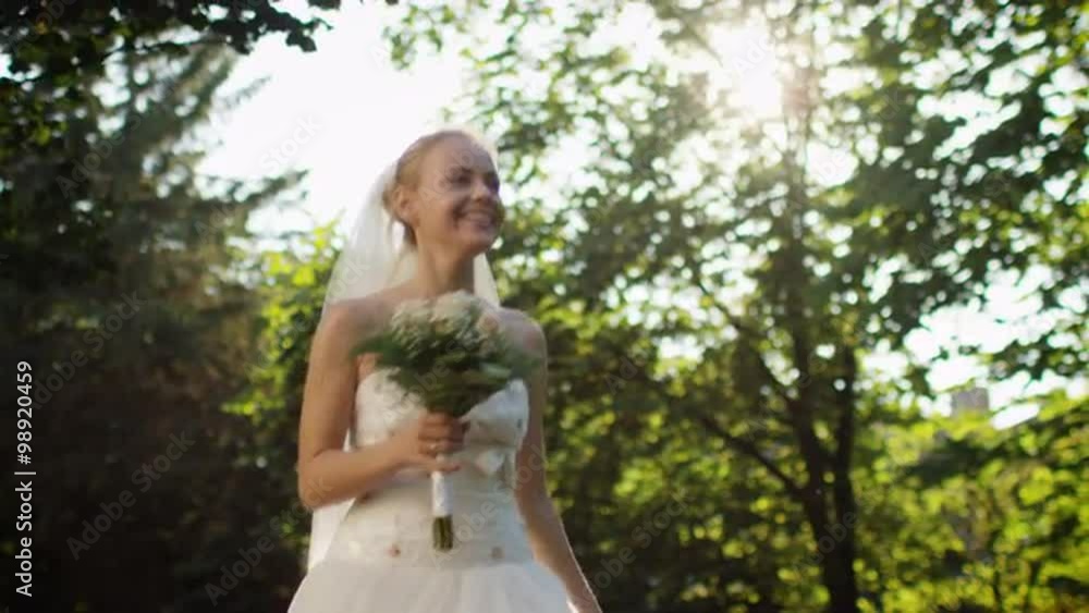 Happy young bride is running in a sunny forest in wedding dress. Happy young bride is running in a sunny forest in wedding dress.
