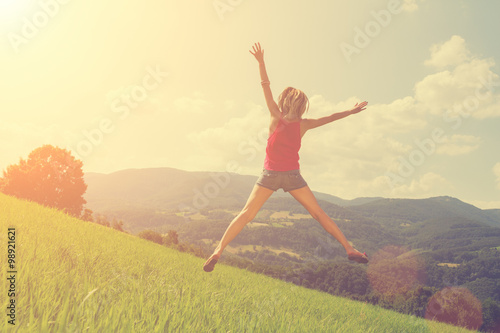 Girl jumping and feeling free in the nature.