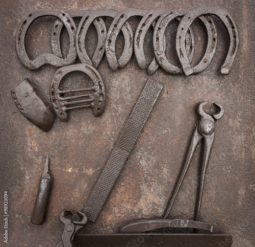 old Horse Shoeing Kit on a rusty metallic background photo