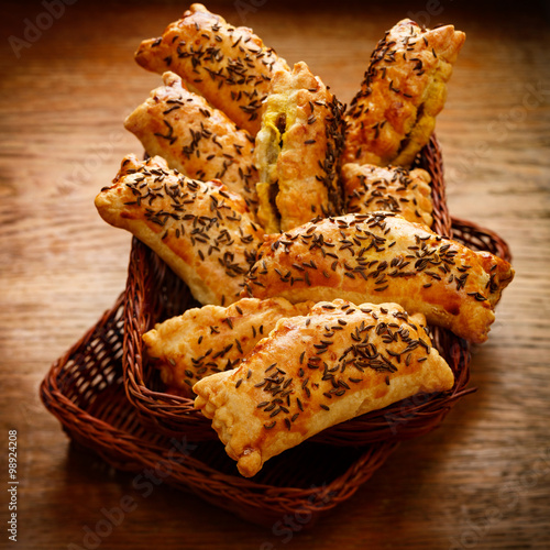 Appetizers with puff pastry stuffed with vegetables sprinkled with caraway seeds