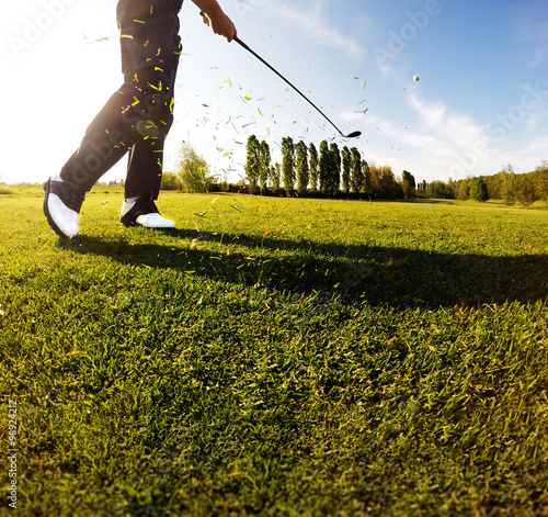 Golf swing on the course. Golfer performs a golf shot photo