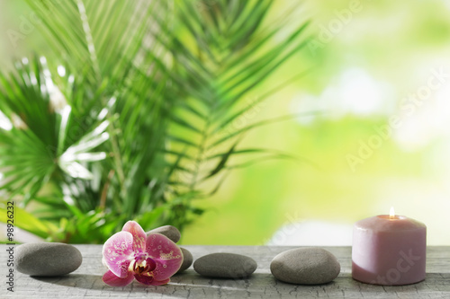 Spa composition of candle  stones and orchid on blurred background