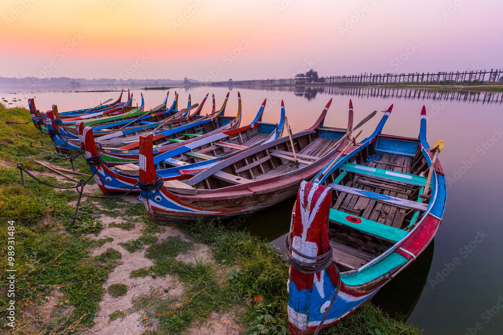 Sunrise at U Bein Bridge with boat, Mandalay, Myanmar.