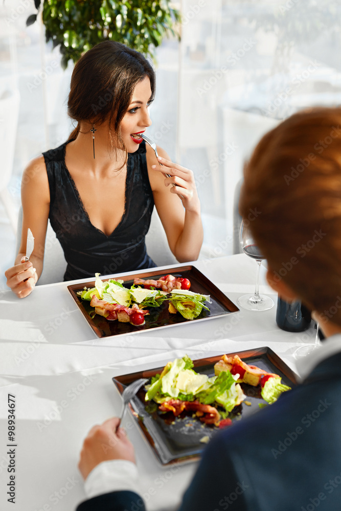 Healthy Food Eating. Closeup Of Young Couple Having Caesar Salad With Roast Chicken, Vegetables And Cheese For Meal In Luxury Gourmet Restaurant. People On Date. Romantic Dinner Or Lunch, Diet Concept