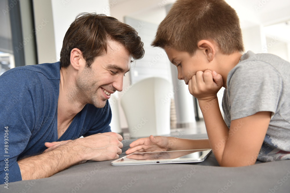 Father and child playing with digital tablet Father and child playing with digital tablet