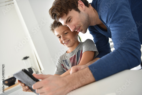 Father and child playing with digital tablet