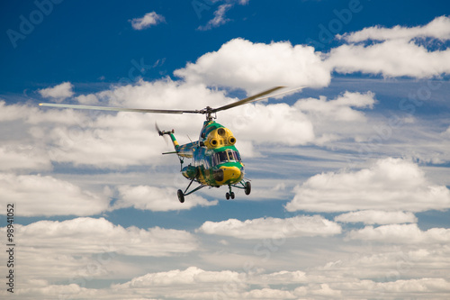 Flying military helicopter in sky background