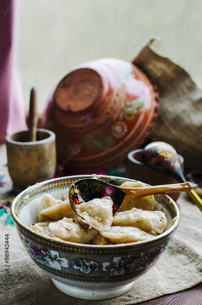 Ukrainian domestic dumplings with cabbage and potatoes in a clay plate
